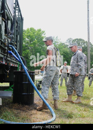 Ein Soldat aus dem 334. Quartiermeister Bataillon erklärt die Ausrüstung auf den simulierten vorwärts Betrieb Basis Generalmajor David W. Puster, Kommandierender general des 84. Training Command, Fort Knox, Kentucky, und Major General Bruce E. Hackett, US Army Reserve Stellvertreter für die 316th Expeditionary Sustainment Command, 78th Training Abteilung, während die Quartiermeister flüssig Logistik Übung am Fort A.P. Hill , VA., am 13. Juni 2014. QLLEX 2014 ist eine gemeinsame Streitkräfte Übung wo liefern 64 Einheiten an acht Standorten in den kontinentalen Vereinigten Staaten mehr als 3,25 Millionen Gallonen petrole Stockfoto