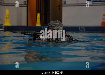 US Armee Sgt. 1. Klasse Frank Minnie, der Unteroffizier verantwortlich für die 4. Public Affairs-Abteilung durchläuft einen Pool auf seinen Rucksack während Wasser Überlebenstraining in Fort Hood, Texas, 24. August 2011. Die Armee Wasser überleben Schulung besteht aus drei Phasen und umfasst Ereignisse wie Hochwasser Eintritt und Buddy Kragen Schlepptau. (US Armee-Foto von Spc. Jenine Shamieh/freigegeben) US Armee Sgt. 1. Klasse Frank Minnie, der Unteroffizier verantwortlich für die 4. Public Affairs-Abteilung durchläuft einen Pool auf seinen Rucksack während Wasser Überlebenstraining in Fort Hood, Texa Stockfoto