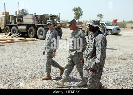 Major General Bernard S. Champoux, links, Kommandierender General der 25. Infanterie-Abteilung und US-Division – Center, Spaziergänge mit Capt Chad Forsythe, zentrieren, Kommandeur des Headquarters und Headquarters Company, "Griffin" spezielle Truppen Bataillon, 2. beraten und unterstützen Brigade der 1. US-Infanteriedivision, US-Division – Center und einem Kewanee Ill., native und 1st Sgt. Eddie Gregory, First Sergeant mit HHC, STB und ein East St. Louis , Ill., Native, 1. September 2011 im Camp Liberty, Irak. Forsythe diskutiert mit Champoux die Pläne des Unternehmens für die Drehung in der Fahrzeuge und der Plan zur Ou schließen Stockfoto