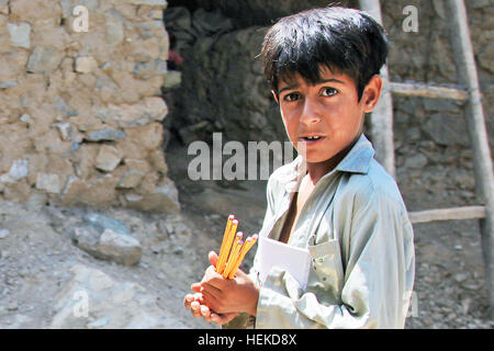 Ein afghanischer Junge geht zurück in seine Heimat mit Schulmaterial, die ihm gegeben wird, während ein Key Leader Engagement im unteren Nawa Dorf Konar Provinz, Afghanistan, 6. September 2011. Schule-Versorgungsmaterialien erhielten die Dorfbewohner von Soldaten der US-Armee aus B Company, 2. Bataillon, 35. Infanterie-Regiment, ein Teil des Key Leader Engagement Routineoperation Task Force Kakteen zu aktivieren, 2-35. Infanterie-Division der lokalen Bevölkerung zu gewinnen und die Aufständischen zu zeigen, dass sie nicht mehr niedriger Nawa Dorf für sicheren Hafen zu nutzen sind. (US Armee-Foto von Spc. Tia Sokimson/freigegeben) Key Leader Engagement 11090 Stockfoto