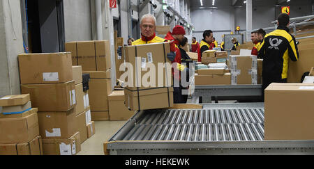 Braunschweig, Deutschland. 21. Dezember 2016. Die Paket-Zusteller Hans-Joachim Harnagel nimmt eine Paket aus dem Förderband auf die DHL-Lieferung in Braunschweig, Deutschland, 21. Dezember 2016. Rund 280 Päckchen und Pakete liefern wir an ihre Empfänger während einer Reise durch die Innenstadt von Braunschweig. Foto: Holger Hollemann/Dpa/Alamy Live News Stockfoto