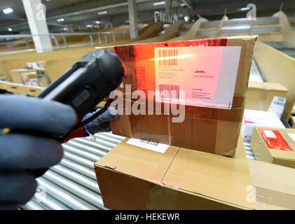 Paket-Zusteller, die Hans-Joachim Harnagel liest den Code auf ein Paket mit einem Scanner bei der DHL-Lieferung Basis Braunschweig, Deutschland, 21. Dezember 2016. Danach wird Harnagel 280 Päckchen und Pakete an ihre Empfänger während einer Reise durch die Innenstadt von Braunschweig liefern. Foto: Holger Hollemann/dpa Stockfoto