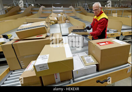 Paket-Zusteller, die Hans-Joachim Harnagel liest den Code auf ein Paket mit einem Scanner bei der DHL-Lieferung Basis Braunschweig, Deutschland, 21. Dezember 2016. Danach wird Harnagel 280 Päckchen und Pakete an ihre Empfänger während einer Reise durch die Innenstadt von Braunschweig liefern. Foto: Holger Hollemann/dpa Stockfoto