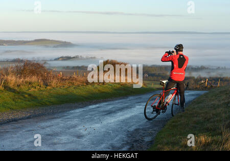 Radfahrer mit dem Fotografieren von Morgen Nebel auf der South Downs nahe Firle, East Sussex Stockfoto