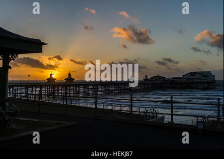 Blackpool, UK. 22. Dezember 2016. Die Sonne geht über Blackpool North Pier an einem bitterkalten Tag von einem verlassenen Promenade als Auftakt zu der Prognose "Sturm Barbara", die durch Treffer der UK Morgen. Das Met Office erwartet Böen von bis zu 90 km/h an Orten während des Sturms. © Andy Gibson/Alamy Live-Nachrichten. Stockfoto