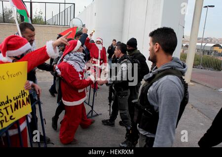 Bethlehem, West Bank. 23. Dezember 2016. Palästinensische Männer als Weihnachtsmann verkleidet und nehmen Teil an einer Protestkundgebung gegen Israels umstrittene Sperranlage im Westjordanland Stadt Bethlehem, am 23. Dezember 2016. © Mamoun Wazwaz/Xinhua/Alamy Live-Nachrichten Stockfoto