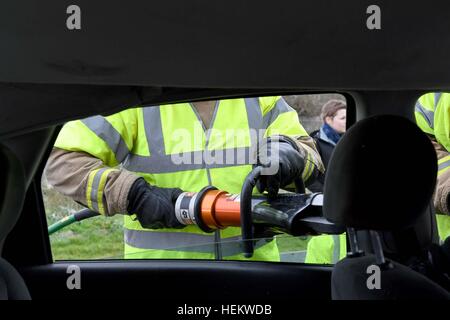 Feuerwehrmann, schneiden Sie das Dach eines Autos bei der Szene einer Unfall-Demonstration, UK. "Autounfall" Szene, RTA oder RTC, abgestürzt Auto mit Feuerwehr-Arbeit Stockfoto