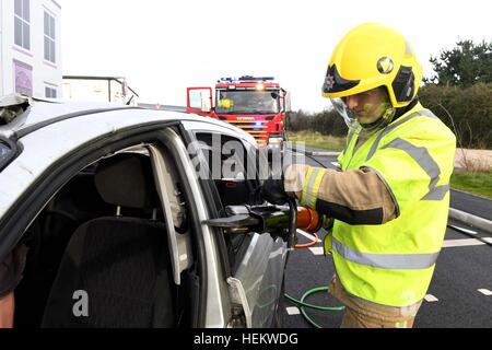 Feuerwehrmann, schneiden Sie das Dach eines Autos bei der Szene einer Unfall-Demonstration, UK. "Autounfall" Szene, RTA oder RTC, abgestürzt Auto mit Feuerwehr-Arbeit Stockfoto