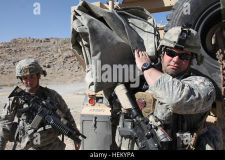 US Army Staff Sgt. Jeremy Longto 19K-Rüstung Mannschaftsmitglied aus Bradford, VT., zusammen mit mit Spc. Ryan Peck, ein 21E-schwere Bau-Ausrüstung-Operator, beide Mitglieder der Alpha Company, 1. Bataillon, 172. Kavallerie-Regiment tragen eine plane, um Vorposten afghanische Nationalpolizei Charikar Bezirk, Parwan Provinz, Afghanistan. Longto und Fellow Troopers besuchen den ANP-Außenposten um die Plane zu verhindern, dass Regen Austritt von Flüssigkeit ins Spenden die ihre lebenden Viertel, Okt. 23. (Foto: U.S. Army Spc. Kristina Gupton) Firma A trifft sich mit einheimischen Führern 334255 Stockfoto