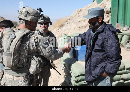 US Army Staff Sgt. Jeremy Longto 19K-Rüstung Mannschaftsmitglied VT., resident, grüßt mit Alpha Company, 1. Bataillon, 172. Kavallerie-Regiment und ein Bradford, ein afghanischer nationaler Polizist bei einem Besuch in den Außenposten in Charikar Bezirk, Parwan Provinz, Afghanistan. Longto und Fellow Troopers besuchen die ANP-Außenposten um eine plane zu verhindern, dass den Regen undicht in ihre Wohnräume zu Spenden und besprechen Sie Sicherheit Kräfte, Okt. 23. (Foto: U.S. Army Spc. Kristina Gupton) Firma A trifft sich mit einheimischen Führern 334257 Stockfoto