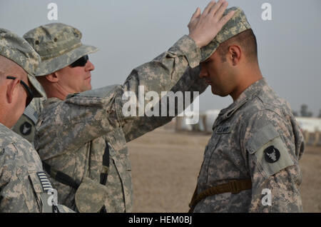 Sgt. Michael Hall White Bear Lake, Minnesota, präsentiert seine neuen Rang seiner Patrouille Kappe von Sgt. 1. Klasse Jeffrey Dahlen von Freeborn, Minn., am Veterans Day. Mit Albert Lea Delta Company, 2. Bataillon, Infanterie-Regiment 135., dienen und liefen Weg Sicherheitspatrouillen im Irak, die Inanspruchnahme zu unterstützen. Geschichte 504926 Stockfoto