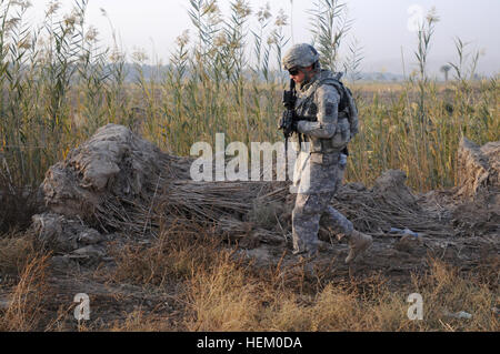 Pvt. Jordan Heistand, ein Schütze zugeordnet, die 2. Brigade, 82nd Airborne Division eine Truppe, 1. Staffel, 73. Kavallerie-Regiment, geht vorbei an Haufen von Pinsel und hohen Unkraut während der Suche Bereich für Bomben am Straßenrand am 15. November. Fallschirmjäger von A Truppe sicherte eine Route in Bagdad für andere Einheiten der Brigade von Camp Ramadi zu Kuwait reisen. Die Truppe hat mehrere Haltestellen entlang der Strecke, überprüfen den Bereich zu Fuß für improvisierte Sprengsätze und Treffen mit irakischen Armeesoldaten an IA Checkpoints. Die 2. Brigade ist die letzte Brigade in Bagdad und fördert den Rückzug der USA Stockfoto