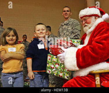 Pvt. Evan Allen Dancer mit Alaska Army National Guard ist alles Lächeln als Santa Claus Hände Geschenke an Schicksal Hawley und ihr Bruder Justin Hawley an der National Guard 3. jährlichen Operation Christmas Blessing im Muscatatuck Urban Training Center in Butlerville, ind., Montag, 12. Dezember 2011.  Kader, Personal und Patriot Akademie Soldaten gehostet t ein Weihnachtsfest, Ständen Kunsthandwerk, carol zum Mitsingen, Musik und gaben Geschenke für Kinder und ihre Familien, die in diesem Jahr kämpfen, um die Runden zu kommen. Soldaten bringen Hoffnung und Trost zu einheimischen Familien in Not 500132 Stockfoto