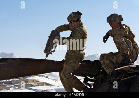 SPC. Walton Lowrey, schneidet aus Ocala, Florida, die Klinge von einem beschädigten Hubschrauber in der Provinz Paktika, Spc. Jacob Stoddard von Bigsby, Idaho dienen als Sicherheit.  Lowrey ist ein Pfadfinder in Task Force Corsair, 82. Combat Aviation Brigade.  Sein Onkel, Sgt. Major Russ Lowrey, ist das Bataillon CMD Sgt. Major Family Business 532082 Stockfoto