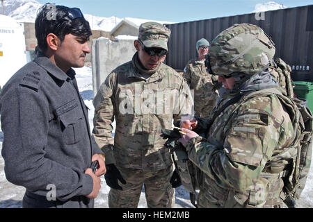 U.S. Army Captain Dan Phillips, aus El Paso, Texas, ist 3rd Brigade Combat Team zugewiesen, 1. US-Panzerdivision aufzeichnen von Notizen während des Gesprächs zu einem afghanischen uniformierten Polizisten mittels eines Dolmetschers über wie sie die Umgebung patrouillieren. Phillips ist der Assistent-Geheimdienst-Offizier für 3rd Brigade Combat Team, 1. US-Panzerdivision. (US Armee-Foto von Spc. Austin Berner/freigegeben) Schlachtfeld Zirkulation Mission 120215-A-BZ540-037 Stockfoto