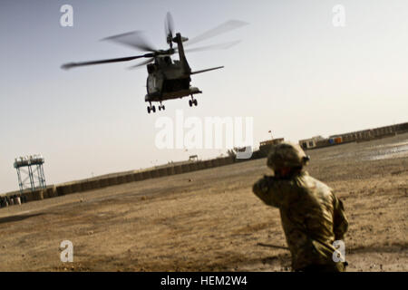 Ein britischer Soldat mit dem 1. Bataillon, den Prinzen von Wales Royal Regiment und ein Hubschrauberlandeplatz Zone Stellwerkswärter Uhren einen Hubschrauber der britischen Royal Air Force HC3 Merlin ausziehen aus der Landezone am Lashkar Gar Training Center in der Provinz Helmand, Afghanistan, 21. Februar 2012. Landezone 120221-A-YI377-512 Stockfoto