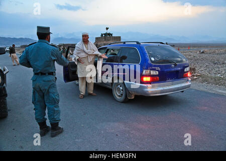 Ein Mitglied der afghanischen Uniformierte Polizei leitet ein einheimischer sein Fahrzeug am Verkehr Checkpoint, im Stadtteil Nazyan, beenden der Provinz Nangarhar, Afghanistan, 10. März 2012. US-Soldaten und Gegenstücke der afghanischen Nationalarmee und AUP durchgeführt, eine Partnerschaft Patrouille um Aufständischen Bewegungsfreiheit zu verweigern. (Foto: U.S. Army Spc. Amber Leach / veröffentlicht) Kombinierte ANA und AUP KLE - Traffic Control Point 120310-A-LP603-198 Stockfoto