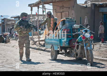 Provinz PAKTIKA, Afghanistan--A US Armee-Soldat mit Firma A, 1. Bataillon, 2. Infanterie-Brigade, 1. Zug, Task Force Blackhawk, wird von einem lokalen jungen während einer Patrouille der Fuß durch das Dorf Yahya Khel, in der Nähe von Combat Outpost Yosef Khel, März 10 begrüßt.  1. Plt. war Mitglieder der afghanischen Nationalarmee und der afghanischen Uniformierte Polizei in das Gebäude von einem Kontrollpunkt im Dorf helfen.  (Foto: U.S. Army Sgt Ken Scar, 7. MPAD) Auf Patrouille mit Task Force Blackhawk Soldaten 120310-A-ZU930-032 Stockfoto