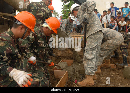 Schulkinder aus Tagbarungis Elementary School, Puerto Princesa City, Palawan, Philippinen, als Ingenieure der Streitkräfte der Philippinen, 51. Engineering Brigade mit ihren Partnern aus der US-Armee betrachten 643rd Engineering Company, 84. Engineering Mrd. Schaufel Beton im Rahmen eines Schulprojektes Gebäude 22 März. Diese engineering Bürgerbeteiligung-Projekt ist ein Teil Balikatan 2012, eine jährliche bilaterale Übung konzentriert sich darauf, gemeinsame Planung, Einsätze und humanitäre Hilfe der bürgerlichen Funktionen der philippinischen und US-Militärangehörige. Philippine, US-serv Stockfoto