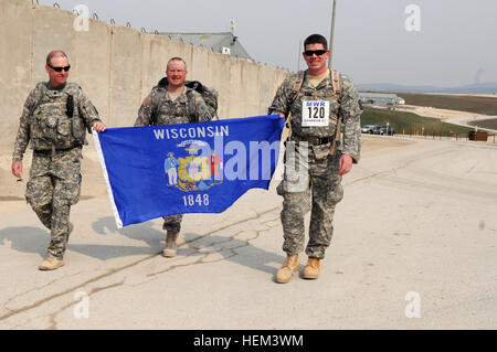 Wisconsin Army National Guard Soldaten (von links nach rechts) Oberstleutnant Kerry Morgan, Chef des Stabes; Oberstleutnant Jon Russell, Operationsoffizier; und Generalmajor Matthew Beilfuss, stellvertretender Operationsoffizier, überqueren die Ziellinie des Todes 13,1 Meilen Bataan Memorial März am Camp Bondsteel, Kosovo März 26. Die Soldaten sind multinationale Kampfgruppe Ost zugeordnet. Task Force Falcon Foto Bataan Memorial Tod März um Camp Bondsteel 791103 Stockfoto