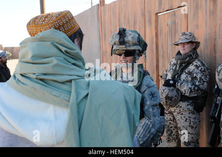 SPC. Elizabeth Manfredini, Sanitäter mit Charlie Kompanie, 81. Civil Affairs Bataillon, Fort Hood, Texas, spricht mit einem afghanischen Role-player als zwei Mitglieder der deutschen militärischen Uhr während einer Trainingsmission bei Kamal Jabour, einem nachgebauten afghanischen Dorf befindet sich in Fort Bliss, Texas, 25. April 2012. Büffel in Aktion 120425-A-DU849-007 Stockfoto