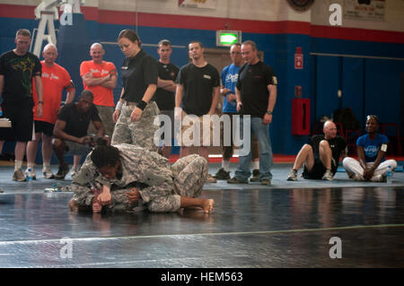 Soldaten kamen in einem Combatives Turnier in Camp Arifjan Zone 1 Turnhalle, 28. März 2012 antreten. Das Turnier war die erste open Turnier hier, jeder Soldat zur Teilnahme bereit zur Verfügung. "Soldaten haben den angeborenen Wunsch zu gewinnen. Um zu gewinnen, muss es einen Wettbewerb der Arten, "sagte 1st Sgt. Luke Grim, First Sergeant der 56. Signal Company und der nicht-Offizier-in-Charge des Camp Arifjan Combatives Programm. "Eine Bruderschaft Formen unter den Wettbewerbern," sagte Grim, "wie die Person über den Ring auch noch durch die Nervosität vor dem Kampf und Nerven zu erhalten. Es ist th Stockfoto