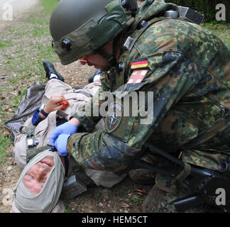 Ein deutscher Soldat von 371. Infanterie-Bataillon bietet medizinischen Hilfe für einen verletzten Zivilisten während ein Operational Mentor Liaison Teams (OMLT)-Übung auf der Joint Multinational Readiness Center in Hohenfels, Deutschland, 5. Mai 2012.  OMLT XXIII und Polizei Operational Mentor Liaison Team (POMLT) VII Ausbildung sollen vorbereiten Teams für den Einsatz in Afghanistan mit der Fähigkeit zu trainieren, beraten, ermöglichen die Afghan National Security Force in Bereichen wie Bekämpfung von Aufständen, Beratung zu bekämpfen und förderlichen Maßnahmen zu erzwingen. (US Armee-Foto von Sgt. Kirk Evanoff/nicht veröffentlicht) Stockfoto