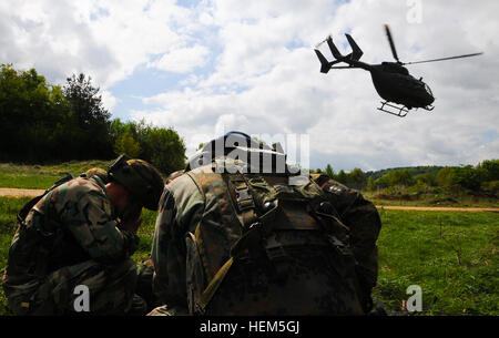 Albanische Armeesoldaten, replizieren Afghan National Army und Bundeswehr-Soldaten aus Operational Mentor Liaison Teams (OMLT) 9, ein Opfer zu sichern, während ein Hubschrauber ab während ein OMLT-Übung auf der Joint Multinational Readiness Center in Hohenfels, Deutschland, 7. Mai 2012 fliegt.  OMLT XXIII und Polizei Operational Mentor Liaison Team (POMLT) VII Ausbildung sollen vorbereiten Teams für den Einsatz in Afghanistan mit der Fähigkeit zu trainieren, beraten, ermöglichen die Afghan National Security Force in Bereichen wie Bekämpfung von Aufständen, Beratung zu bekämpfen und förderlichen Maßnahmen zu erzwingen. Stockfoto