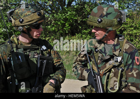 Ein deutscher Soldat von militärischen Berater Team 3, spricht mit einem albanischen Soldaten, replizieren Afghan National Army, während ein Operational Mentor Liaison Teams (OMLT)-Übung auf der Joint Multinational Readiness Center in Hohenfels, Deutschland, 10. Mai 2012.  OMLT XXIII und Polizei Operational Mentor Liaison Team VII Ausbildung sollen Einsatz in Afghanistan mit der Fähigkeit zu trainieren, beraten und ermöglichen die Afghan National Security Force in Bereichen wie zur Niederschlagung von Aufständen, Bekämpfung Beratungs- und Kraft ermöglicht Operationen zur Unterstützung des Teams vorbereiten. (US Armee-Foto von Sgt. Kirk Evanof Stockfoto