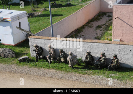 Ein ukrainischer Soldat replizieren afghanischen Uniform Polizei, bulgarische Soldaten replizieren von Afghan National Security Force (ANSF) und kroatische Soldaten von Recon Company, Garde Motorisierte Brigade Stapel an der Wand vor tätlichen Angriffs auf ein Haus, während ein Operational Mentor Liaison Teams (OMLT) Training trainieren Sie im das Joint Multinational Readiness Center in Hohenfels, Deutschland, 15. Mai 2012.  OMLT XXIII und Polizei Operational Mentor Liaison Team VII Ausbildung sollen Mannschaften für den Einsatz in Afghanistan vorbereiten, mit der Fähigkeit zu trainieren, beraten und ermöglichen die ANSF in Bereichen wie Bekämpfung von Aufständen, Stockfoto