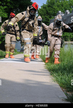 Mitglieder der Kentuckys 301. und 299. Chemieunternehmen Wurf tragen ein verletztes Opfer bei einem simulierten Angriff mit chemischen, biologischen, radiologischen und nuklearen Materials im Muscatatuck Urban Training Center in Butlerville, ind. 23. Mai 2012.  Opfer waren aus der heißen Zone extrahiert und getroffen, um einen Bereich Dekontamination, wo sie medizinische Behandlung erhalten und veröffentlicht wurden. CERFP Übung 120523-A-WA628-008 Stockfoto