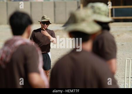 Ein Soldat der britischen Armee mit der Königin eigenen Royal Gurkha Logistic Regiment, angeschlossen an das 1. Bataillon, Welsh Guards, spricht über, die bis zur Fledermaus während einer Grille in Lashkar Gah Training Center, überein, ist der Provinz Helmand, Afghanistan, 14. Juni 2012. Die britischen Soldaten verlor gegen die Afghanen 155-50. Cricket 120614-A-YI377-0642 Stockfoto