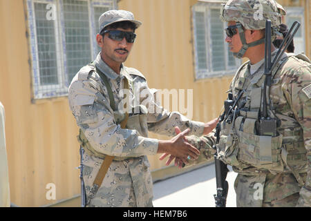 Ein Mitglied des afghanischen biometrische Teams grüßt ein US-Soldat mit 2. Bataillon, 77. Feldartillerie-Regiment, 4th Brigade Combat Team, 4. US-Infanteriedivision, Task Force 2-77, patrouillieren die Torkham Tor, Provinz Nangarhar, Afghanistan, 19. Juni 2012 dienen. Diese Mission war, damit der afghanischen nationalen Sicherheitskräfte bei der Suche die Führung übernehmen, während die Mitglieder der Task Force 2-77 biometrischen Scans durchgeführt. (Foto: U.S. Army Staff Sgt Kelvin Lovelist / veröffentlicht) Torkam Tor Suche 120619-A-DL472-037 Stockfoto