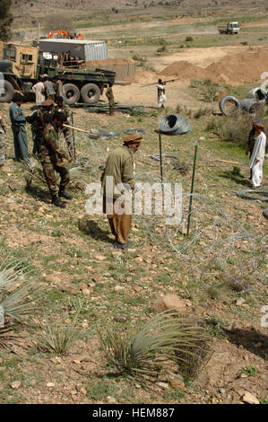 Am 29. März stellen afghanische Grenzpolizei Offiziere ein Bündel von Konzertina Draht in Position für den Ausbau der Bara Tane Grenze Check Point in der Khowst Provinz von Afghanistan. Bara Tane Grenze Check Point Expansion 41231 Stockfoto