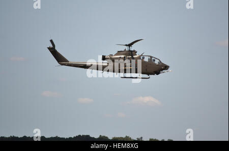 Ein Bell AH-1 Cobra-Hubschrauber fliegt niedrig über der Baumgrenze als Schutz für die Vietnam-Ära Air Assault und Rettung in der Morgendämmerung, einer simulierten Rettung eines abgestürzten Piloten während der Super Samstag Air Show in Fort Campbell, Kentucky, Aug. 11. Die Airshow ist eine der Hauptattraktionen während der jährlichen Woche der Eagles, die feiert 70. Jahrestag der 101st Airborne Division und ehrt seine Geschichte von Tapferkeit. (Foto: U.S. Army Spc Jennifer Andersson, 159. Combat Aviation Brigade Public Affairs/freigegeben) 101st Airborne Division Airshow begeistert Zuschauer 120811-A-ZT847-528 Stockfoto