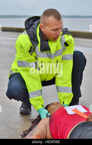 Michael Fox, ein Feuerwehrmann-Notfall medizinische Techniker Sanitäter, die 596th Transport-Brigade zugewiesen Military Ocean Terminal Sunny Point, NC, sorgt für ein Opfer eines mock Kai Brandes während der Punkt Defender 2012 Übung Aug. 20-23 auf MOTSU.  Das Szenario war eine von Dutzenden von Veranstaltungen, die während der vier-Tage-Übung entfaltet.  Punkt-Defender ist ein Militäreinsatz Oberfläche und Verteilung Befehl Bekämpfung des Terrorismus und Kraft-Schutz-Übung jährlich abgehaltenen MOTSU.  Als Teil der Übung, Personal zugewiesen, um die 596th Trans-Bde. Dutzende von Szenarien des durchgearbeitet Stockfoto