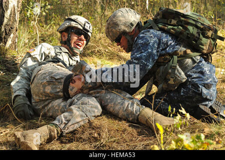 U.S. Navy Hospital Corpsman zweiter Klasse Sean Miller (rechts), Europa Regional Medical Command zugeordnet, gilt eine Blutsperre für einen simulierten Unfall während der Bekämpfung Spur beim US Army Europe Expert Bereich medizinische Abzeichen Wettbewerb in Grafenwöhr, Deutschland, 18. September 2012. US Army Europa Experten Bereich Medical Abzeichen 2012 120918-A-BS310-039 Stockfoto