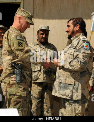 Major General Chris Hughes links (), der stellvertretender Kommandierender General des Manövers für Regional Command (Süd), erhält ein Zeichen der Wertschätzung von afghanischen gen Tashfir Khan, Kommandeur der 3. Zone afghanische Grenzpolizei, während eine Explosive Gefahr Reduktionspfad Abschlussfeier am Camp Hero, Afghanistan 22. Oktober 2012. 29 afghanische Grenzpolizei Absolvent von der Explosive Gefahr Verringerung Kurs 121022-A-VC646-379 Stockfoto