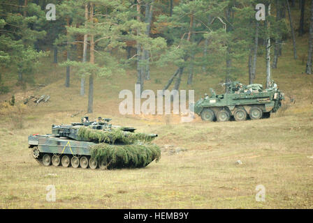 Ein deutsche Armee Leopard II Panzer, 104. Panzer Bataillon, zugewiesen bewegt sich von einem US Army Europa Stryker-Fahrzeug, nach der Zerstörung der Stryker während Saber Junction 2012 bei den Joint Multinational Readiness Center in Hohenfels, Deutschland, Okt. 25, 2. Kavallerie-Regiment zugewiesen. Die US Army Europe Übung Saber Junction Züge U.S. Personal- und 1800 multinationale Partner aus 18 Nationen eine multinationale Interoperabilität und eine agile, bereit Koalition Kraft.  (US-Army in Europa Foto von visuellen Informationen Spezialist Markus Rauchenberger/freigegeben) Armour während Saber Junction 2012 in Ho Stockfoto