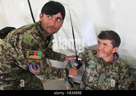 Soldaten der afghanischen Nationalarmee üben während des Trainings auf der Forward Operating Base Airborne in der Provinz Wardak, Afghanistan, die Anwendung von Tourniquet und Kampfverfahren aus, um die medizinische Bereitschaft auf dem Schlachtfeld zu verbessern. Stockfoto