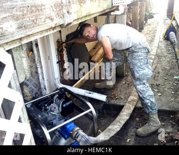 Staff Sergeant James Forkhamer Jr., ein Taucher befestigt, das spezielle Truppen Bataillon, 7. Sustainment Brigade, Fort Eustis, Virginia, neigt dazu, eine Wasserpumpe in einer Wohngegend von Staten Island, N.Y. 12. November. Er ist Teil eines Teams von Tauchern an der STB, die im Großraum New York nach der Beschädigung durch Hurrikan Sandy Okt 29 links unterstützt befestigt. Resolute Brigade Taucher unterstützen NY nach Hurrikan Sandy 790533 Stockfoto