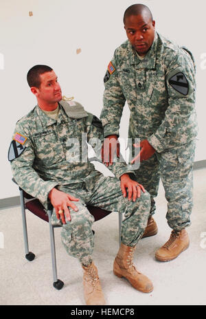 Master Sergeant Olanda James (rechts), aus Knoxville, Tennessee, medizinische Operationen Unteroffizier verantwortlich, 1. ACB, 1. CAV Div. zeigt die korrekte Position um eine Blutsperre im Falle einer Armverletzung als Testperson Sgt. John Brockway, von Copperas Cove, Texas, technische Flugzeug Inspektor, Firma D gelten 2-227. Aviation Regiment, 1st ACB, blickt auf eine während der Bekämpfung Lebensretter Rezertifizierung training Dez. 12 , hier. (Foto von 1st Lt. Alun Thomas, 1. ACB, 1. Cav. Div. PAO) 1. ACB Troopers Schärfe Bekämpfung lebensrettende 802903 Stockfoto