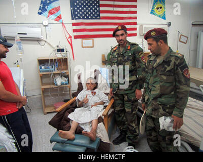Afghanische Kommandos der 8. Sondereinsätze Kandak unterstützten einen achtjährigen Jungen in einer medizinischen Einrichtung in Tarin Kowt, Provinz Uruzgan, Afghanistan, am 14. September 2013. nachdem er bei einem Schießereignis in der Provinz Kandahar verwundet wurde, leistete er Notfallversorgung und Unterstützung. Stockfoto