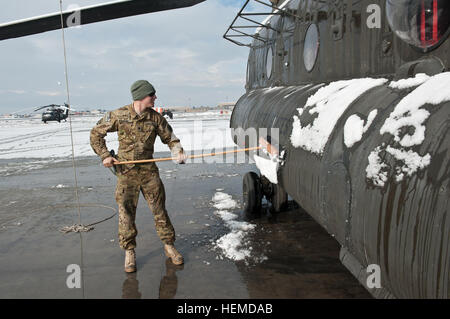 SPC. Zachary Vehrs, B Company, 1. Bataillon, 126. Aviation Regiment, kalifornischen Nationalgarde, Task Force Shadow, fegt Schnee von der Seite ein CH-47 Chinook-Hubschrauber der 101st Combat Aviation Brigade Flightline, Bagram Air Field, Afghanistan, 12. Januar 2013.  (Foto: US-Armee Sgt. Duncan Brennan, 101. CAB-Öffentlichkeitsarbeit) Wings of Destiny Aufräumen nach Schneesturm 130112-A-IA071-088 Stockfoto