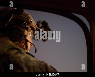 Mitglied des afghanischen und Koalition Sicherheitsteam Kraft schaut aus dem Fenster ein CH-47 Chinook vor einer Operation in Nad ' Ali District, Provinz Helmand, Afghanistan, 27. Januar 2013. Die Operation führte zur Festnahme eines Taliban-Führer, der seine Untergebenen mit tödliche Hilfe und Zubehör für den Einsatz in Angriffe auf afghanische und Koalition Kräfte ausgestattet. Er verwies die Verteilung von schweren Maschinengewehren und Raketen an seine untergeordneten Kämpfer.  (Foto: US-Armee von Sgt. Richard W. Jones Jr.) Betrieb in Nad ' Ali Bezirk 130127-A-QU939-034 Stockfoto