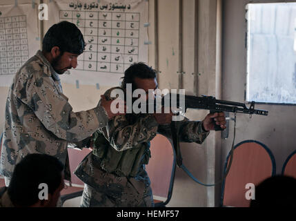 Afghanischen Grenze Polizei Sgt. Noor Ulmah Züge links, ein neues Mitglied der Polizei in grundlegende Gewehr Fähigkeiten bei Combat Outpost Bowri Tana Khost Provinz, Afghanistan, 2. März 2013. Ulmah ist ein Training-Unteroffizier der Treffsicherheit, Fahrzeug suchen und erste Hilfe unterrichtet. (US Armee-Foto von Spc. Alex Kirk Amen/freigegeben) Rakkasans trainieren afghanische Grenzpolizei Treffsicherheit 130301-A-NS855-010 Stockfoto