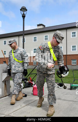 Von rechts startet US-Armee Spc. Cameron Caruthers, ein motor Transport Operator mit 606th vorwärts Unterstützungskompanie, 1. Bataillon, 377. Feldartillerie-Regiment 17. Fires Brigade, ein Unkraut Trimmer als Sgt. Edwards Nova, ein motor Transportunternehmen ihre Fortschritte beim Frühjahrsputz bei Joint Base Lewis-McChord, Wash., 11. April 2013 Umfragen.  (US Armee-Foto von Spc. Nathan Goodall/freigegeben) "Outlaw" Soldaten kämpfen gesetzlosen Rasen während Frühjahrsputz 130411-A-AU369-558 Stockfoto