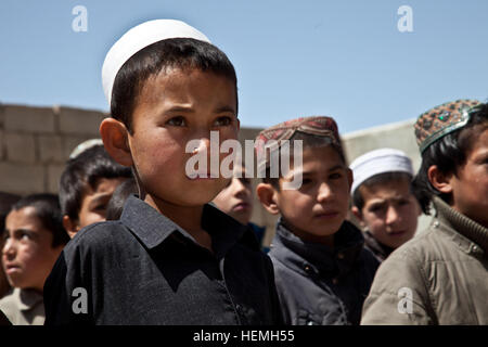 Afghanischer Junge wartet auf einen Rucksack an der All-Boys Paschtu Abad School in Ghazni District, Provinz Ghazni, Afghanistan, 20. April 2013. Khalilullah Hotak, ein Mitglied der Provinz Nejat sozialen Rat von Ghazni verteilte Rucksäcke und Schreibtische für die Schule, die mehr als 600 jungen unterrichtet. Die Nejat Sozialrat Ziel ist es, Unterdrückung, Korruption und Ungerechtigkeit in Abstimmung mit der afghanischen Regierung zu beseitigen.  (US Armee-Foto von Spc. Jessica Reyna DeBooy/freigegeben) Pashtu Abad Schule 130420-A-SL739-168 Stockfoto