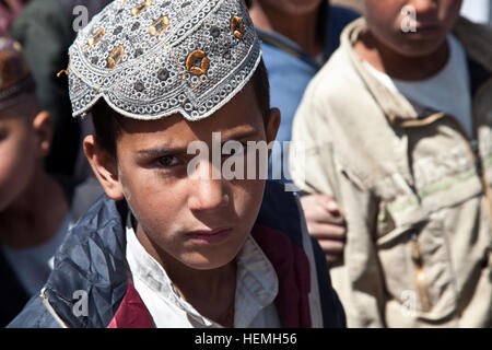 Afghanischer Junge wartet in einer Linie ein Rucksack an der All-Boys Paschtu Abad School in Ghazni district, Provinz Ghazni, Afghanistan, 20. April 2013. Khalilullah Hotak, ein Mitglied der Provinz Nejat sozialen Rat von Ghazni verteilte Rucksäcke und Schreibtische für die Schule, die mehr als 600 jungen unterrichtet. Die Nejat Sozialrat Ziel ist es, Unterdrückung, Korruption und Ungerechtigkeit in Abstimmung mit der afghanischen Regierung zu beseitigen.  (US Armee-Foto von Spc. Jessica Reyna DeBooy/freigegeben) Pashtu Abad Schule 130420-A-SL739-154 Stockfoto