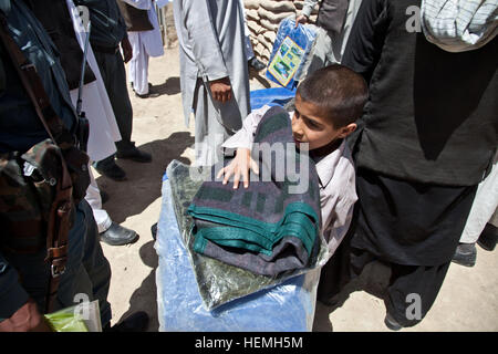 Lokalen afghanischen junge geht nach Hause nach empfangenden Kleidungsstücke aus der Giro Bezirk Polizeichef in Ghazni, Provinz Ghazni, Afghanistan, 20. April 2013 Bezirk. Giro DCoP Mohammad Ahmedi, Khalillluah Hotak und afghanische Polizei verteilt decken und Kleidungsstücke zu einem lokalen Dorf im südlichen Stadt Ghazni.  (US Armee-Foto von Spc. Jessica Reyna DeBooy/freigegeben) Pashtu Abad Schule 130420-A-SL739-059 Stockfoto